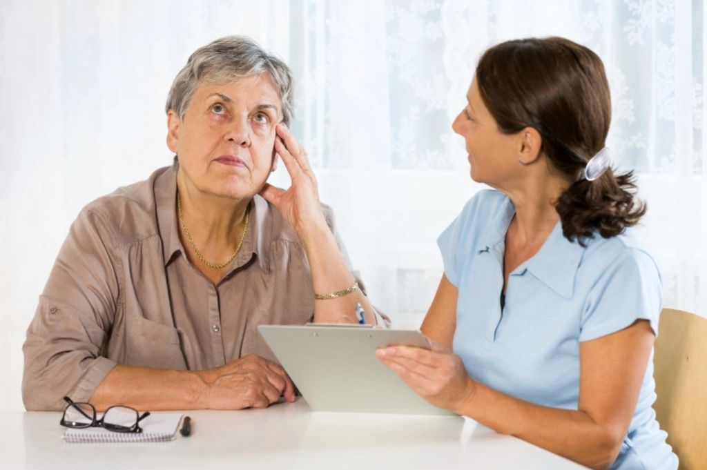 Older adult discussing memory concerns with a healthcare professional during a cognitive assessment consultation.